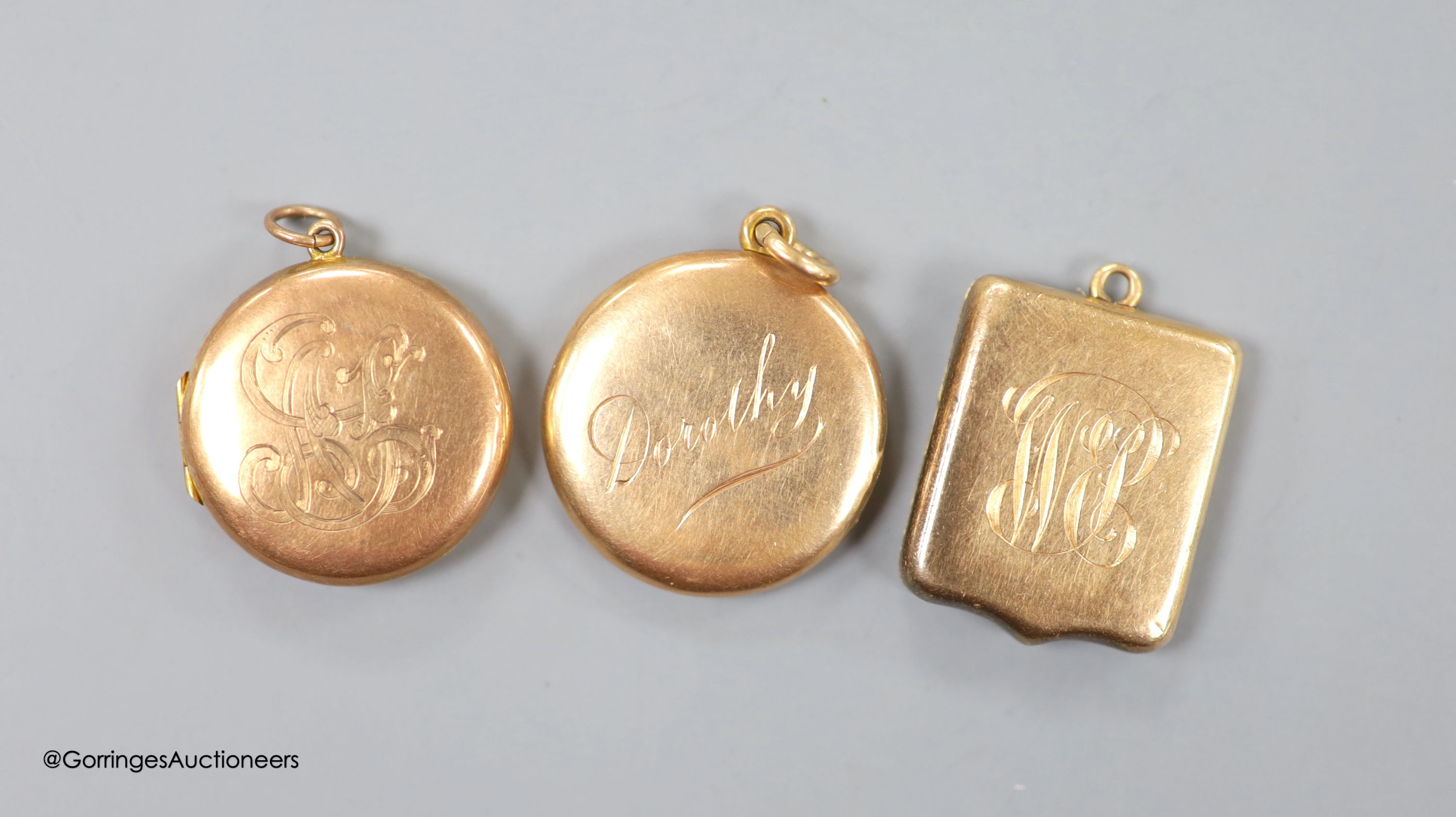 Three early 20th century yellow metal lockets, one stamped 9ct gold, all with engraved name or monogram, largest 24mm, gross weight 22.1 grams.